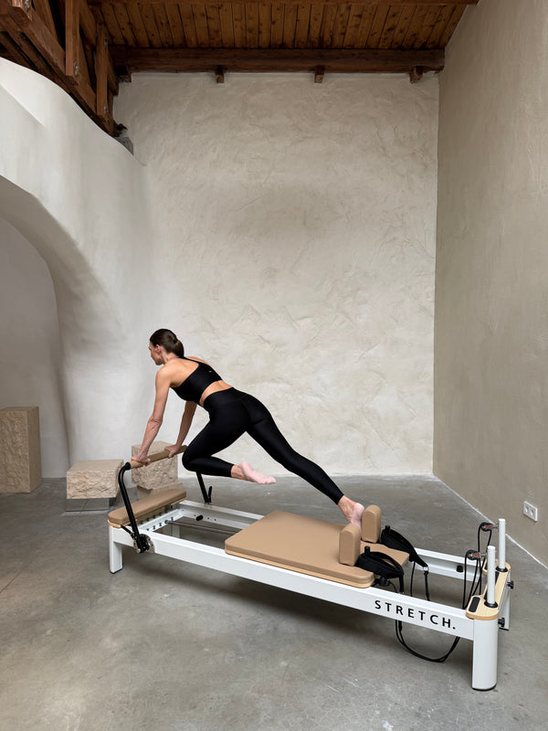 Client using the STRETCH reformer in her home studio