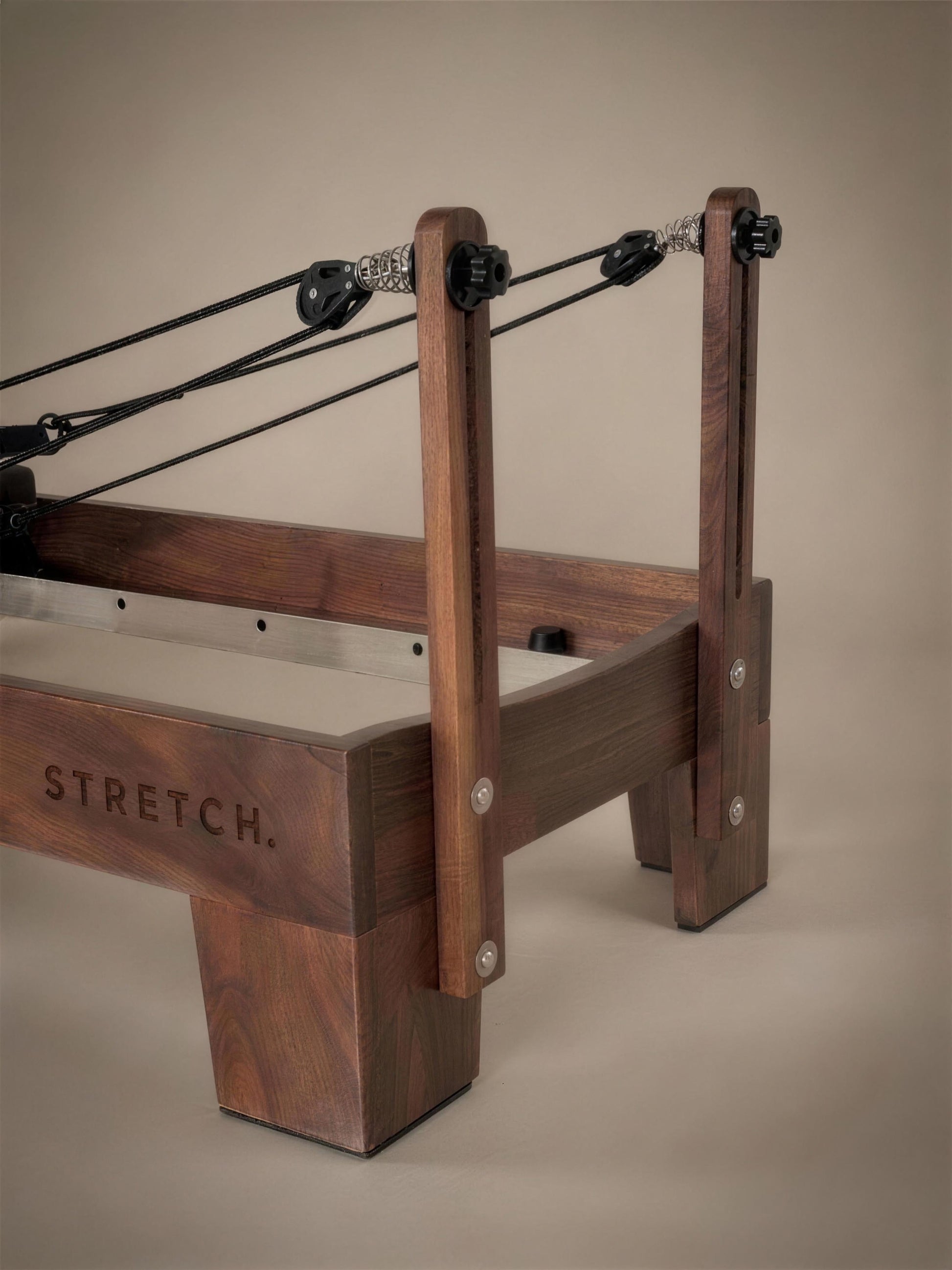 Achteraanzicht van de STRETCH walnut reformer met touwen en veersysteem